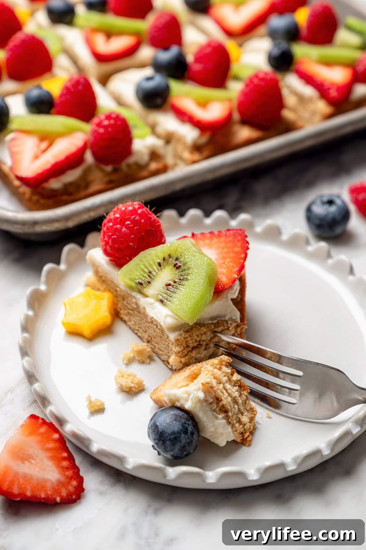 Fruit pizza on plate with tip cut off with fork