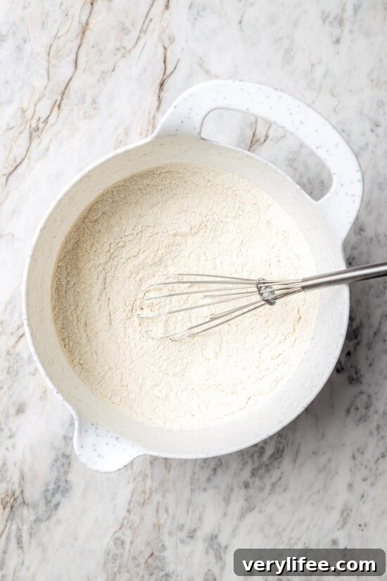 Overhead view of dry ingredients in mixing bowl with whisk