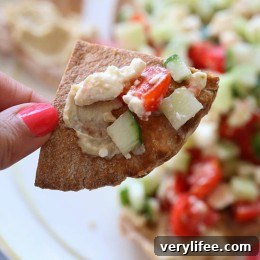 Greek Nachos plated with hummus and fresh toppings