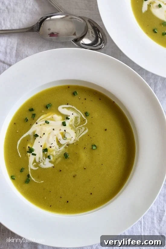 Bowl of creamy asparagus leek soup garnished with creme fraiche and chives