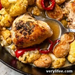 Spoon scooping chicken scarpariello from pan.