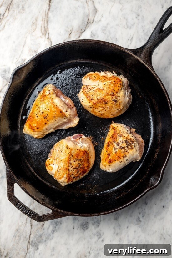 Low-Carb Chicken Scarpariello Recipe 6 Chicken breast halves browning in cast iron skillet.