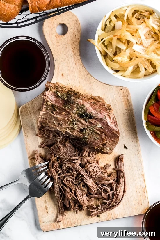 Slow Cooker French Dip Sandwich with Caramelized Onions filled with beef, melted cheese and au jus (beef broth) for dipping–the perfect weekend crock pot recipe!