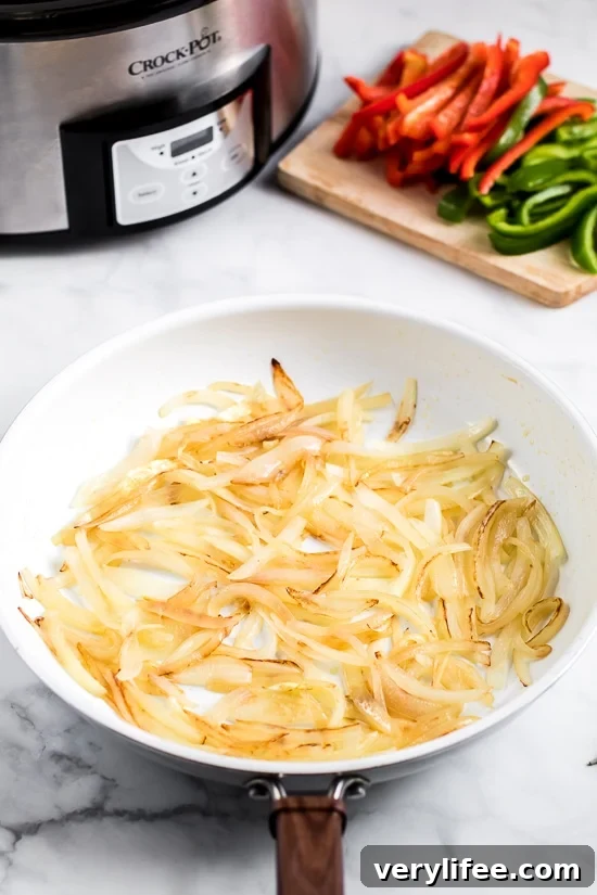 Slow Cooker French Dip Sandwich with Caramelized Onions filled with beef, melted cheese and au jus (beef broth) for dipping–the perfect weekend crock pot recipe!