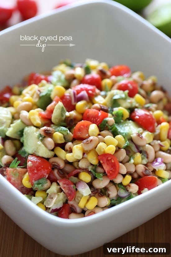 A bowl of black-eyed peas mixed with tomatoes, corn, avocado, and fresh cilantro
