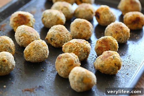 Baked Mini Spinach and Sausage Arancini Bites 6 A sheet pan with baked crispy mini arancini rice balls