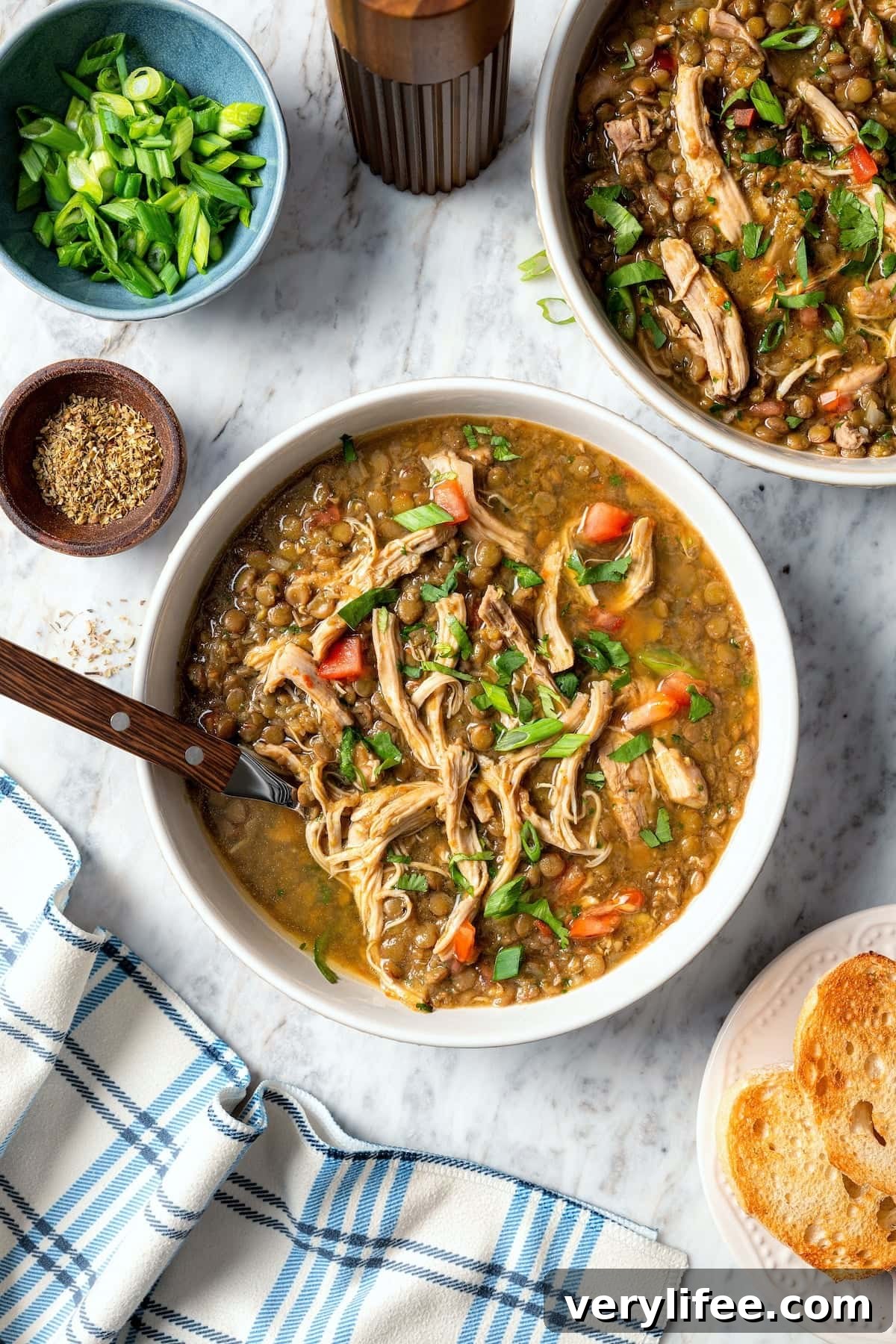 This chicken lentil soup is hearty, flavorful, and easy to make. It’s a nourishing, protein-packed meal perfect for cold days. Two bowls of chicken lentil soup with cilantro.