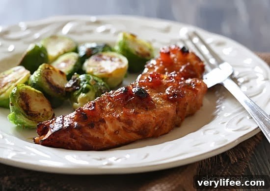 A plate with broiled wild salmon with cherry apple chutney and roasted brussels sprouts