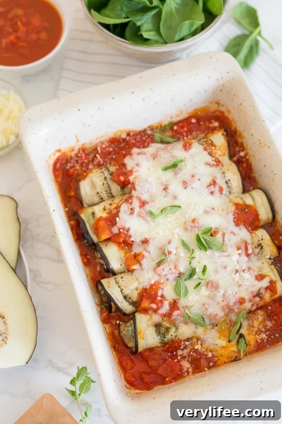 Overhead view of baked eggplant rollatini in a baking dish.