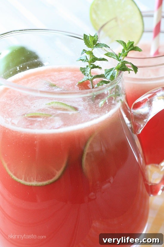Watermelon agua fresca in a pitcher with mint and lime.