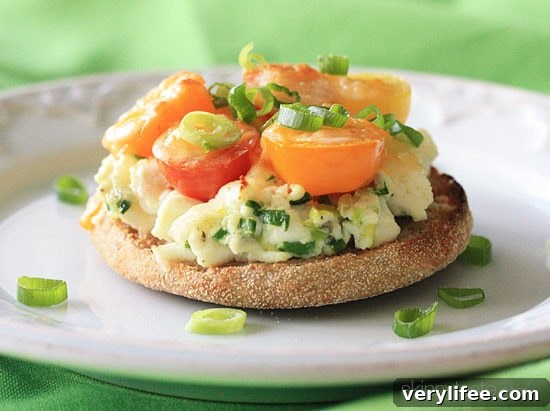 Open faced egg and tomato breakfast melts on whole grain English muffins.