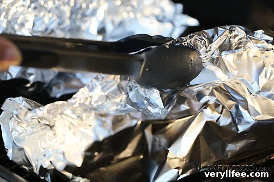 Fish fillet in foil with lemon slices and herbs