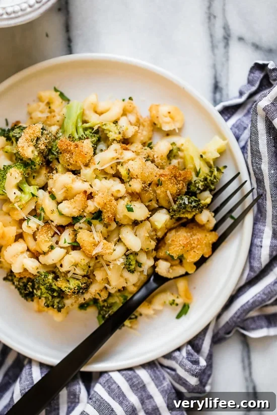 Creamy, cheesy, and packed with veggies, this lightened-up broccoli mac and cheese delivers kid-friendly comfort without feeling too heavy. Plate of broccoli mac and cheese with fork.