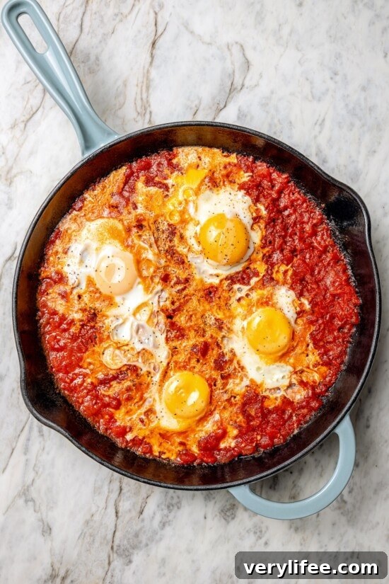 Cook until eggs are set Overhead view of eggs in purgatory in skillet