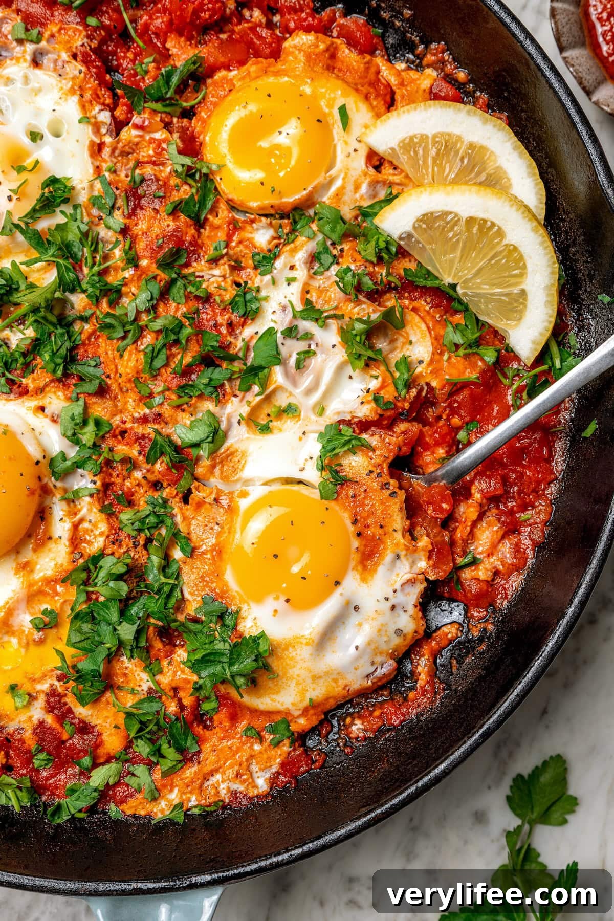 Eggs in purgatory with harissa Overhead view of eggs in purgatory in skillet with spoon