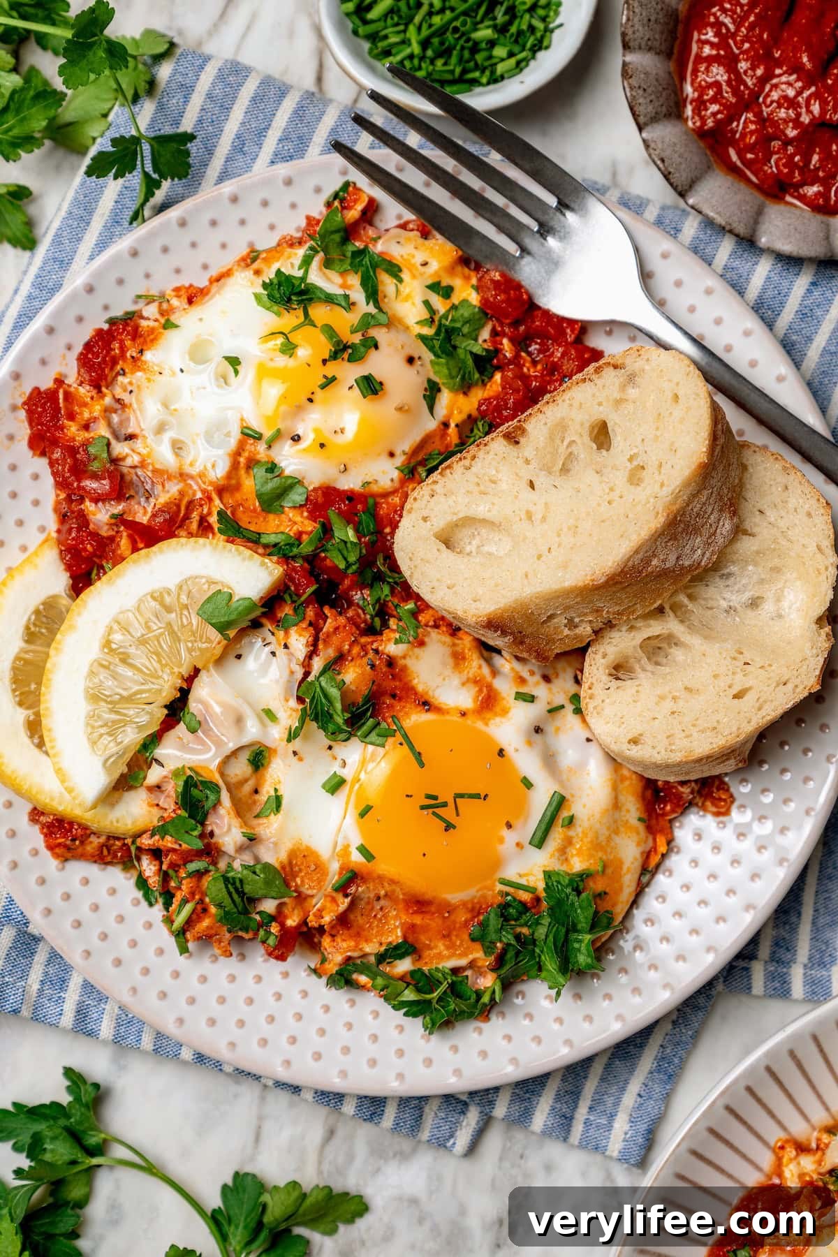 Eggs in purgatory plated Overhead view of eggs in purgatory on plate with slices of bread