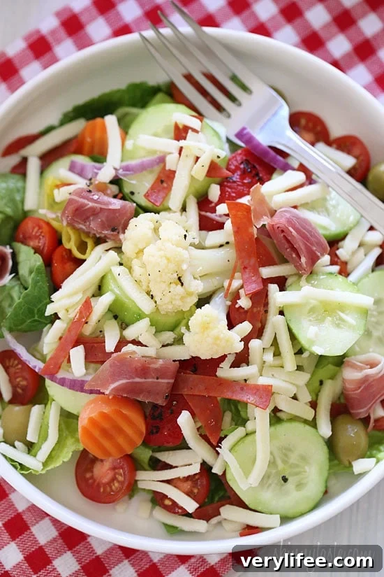 Chopped romaine hearts, shredded mozzarella, olives, prosciutto, turkey pepperoni, roasted red peppers, cucumbers, tomatoes, pepperoncini and Giardiniera (colorful vegetables in vinegar) – this quick Italian antipasto salad requires no cooking, which makes it perfect to whip up or pack for lunch.