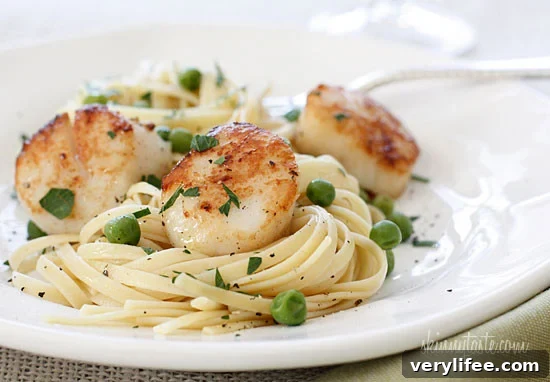 Scallops are great for a quick meal any night of the week and are a real treat. They can be quickly sautéed, then added to salads like this Scallop and Baby Green Citrus Mojo Salad, and this delicious Scallop and Grapefruit Salad, but once in a while when I want something more substantial, I love it with pasta. Here I tossed it with some pasta and peas, for a dinner that took less than 15 minutes to make.