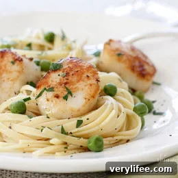 Scallops plated with linguini and peas