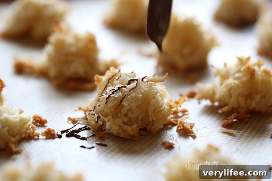 Chocolate drizzled coconut macaroons on a plate