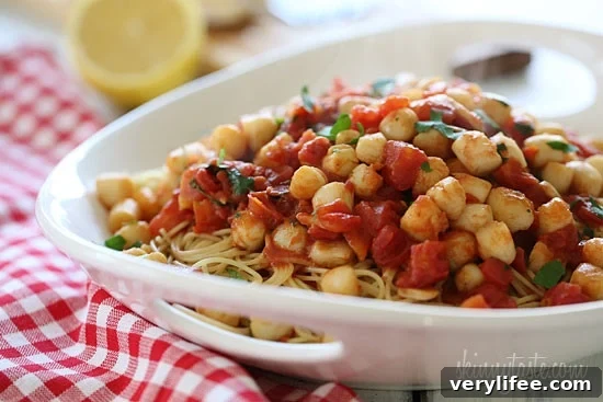 Sauteed bay scallops with tomatoes and a touch of white wine and lemon juice served over angel hair pasta.