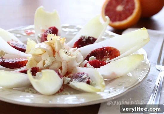Blood Orange Endive Salad with Citrus Vinaigrette 2 A plate with endive pieces with a blood orange segment in each, topped with Gorgonzola cheese