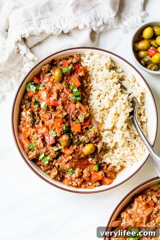 Crock Pot Picadillo is a flavorful Cuban dish made with ground beef and a sauce made from simmering tomatoes, green olives, bell peppers, cumin, and spices.