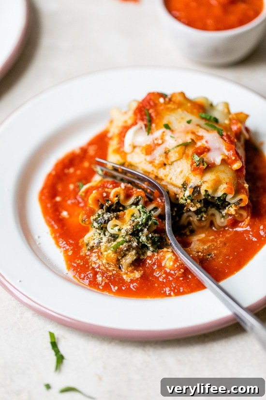 Mushroom Kale Lasagna Rolls with a fork.