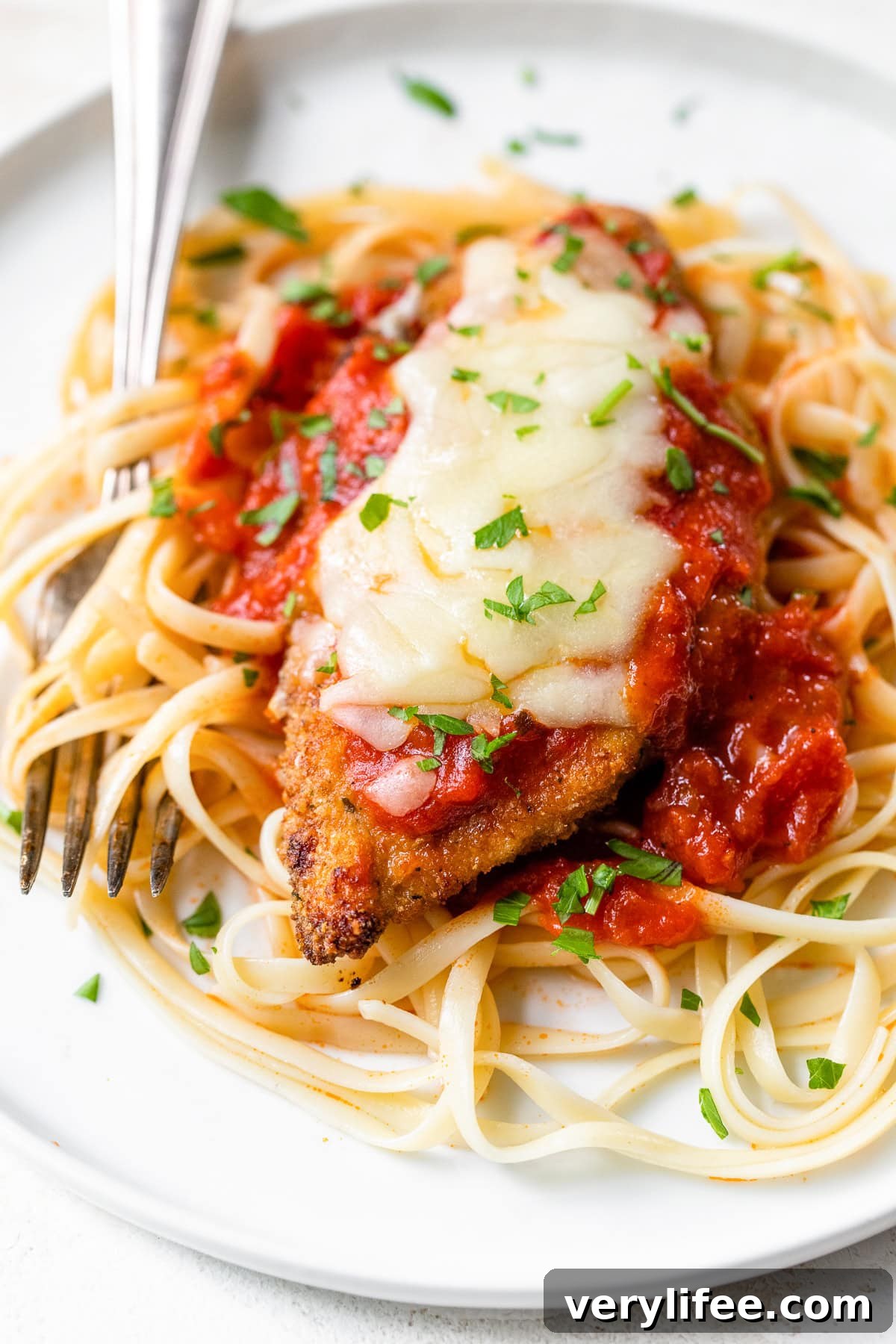 Chicken Parmesan with pasta and a fork