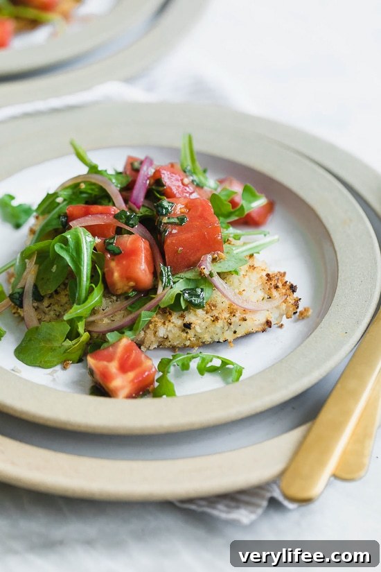 Baked Chicken Milanese is made with breaded chicken cutlets, baked in the oven topped with arugula, tomatoes and balsamic. This is my favorite restaurant dish, made healthier!