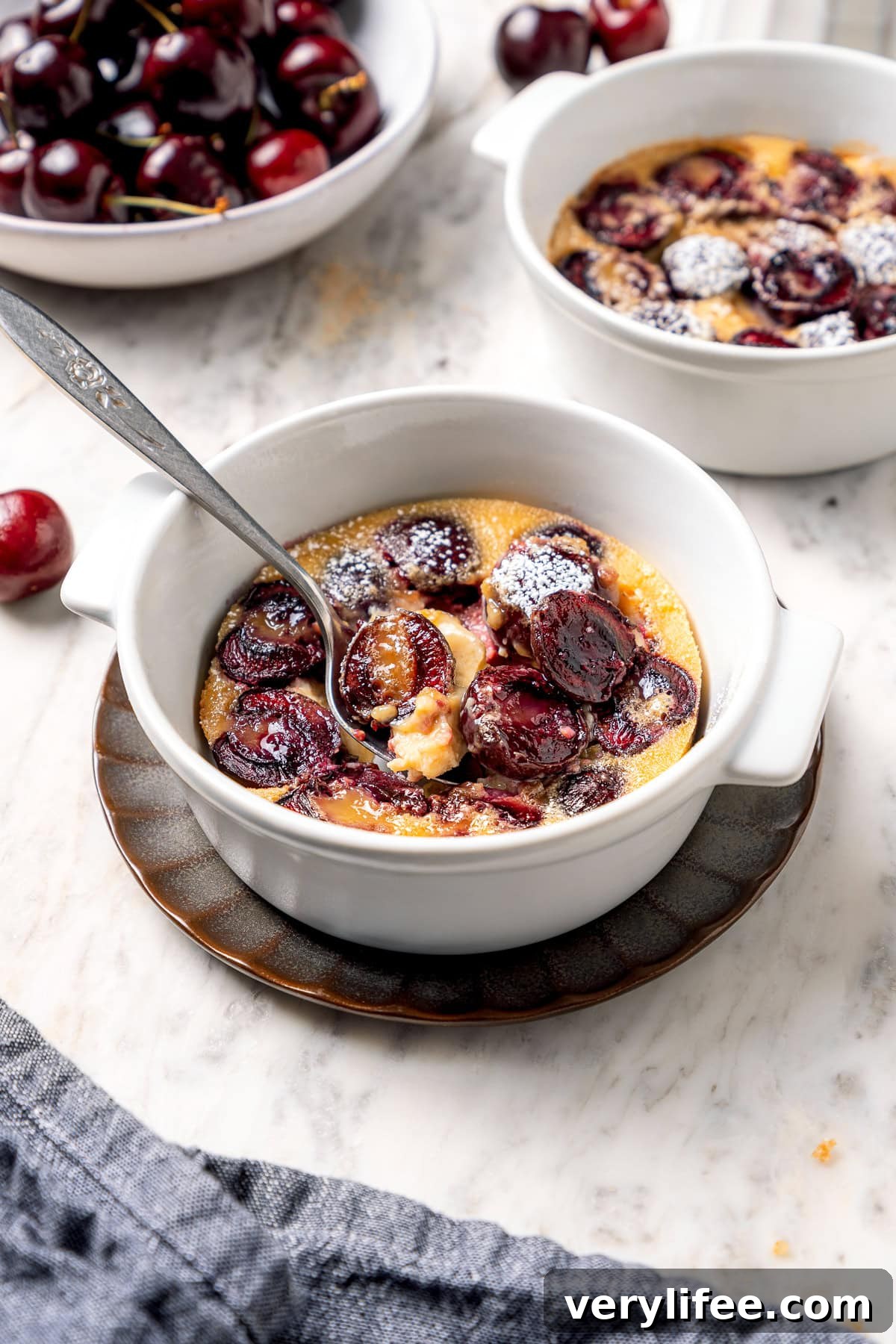 Spoon digging into cherry clafoutis.