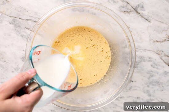 Pouring milk into clafoutis batter.