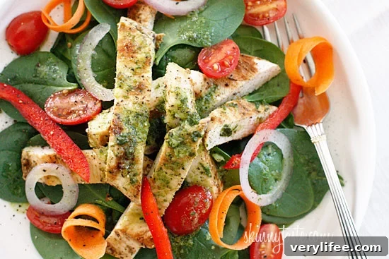Grilled chicken on a colorful spinach salad with white balsamic vinaigrette