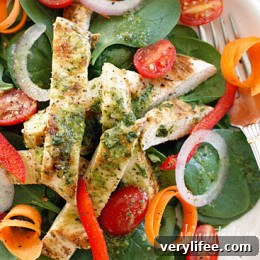 Final plated grilled chicken spinach salad with dressing