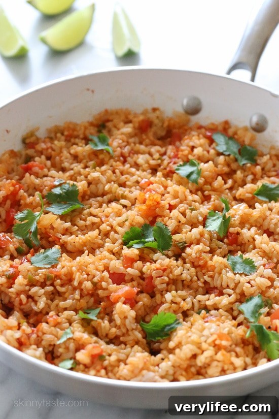 Want to know how to cook perfect brown rice? This easy, foolproof brown rice recipe will give you perfect rice that is never sticky. A pan filled with fluffy Mexican brown rice.