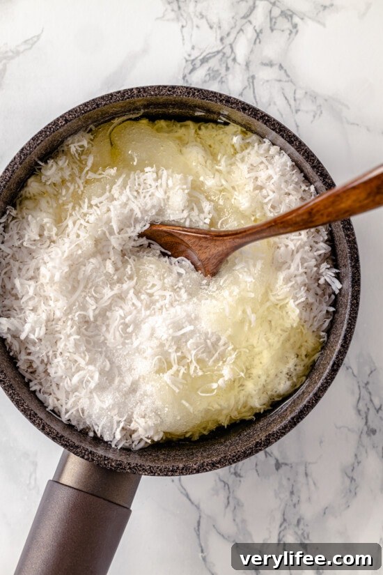 A wooden spoon stirring shredded coconut and egg whites