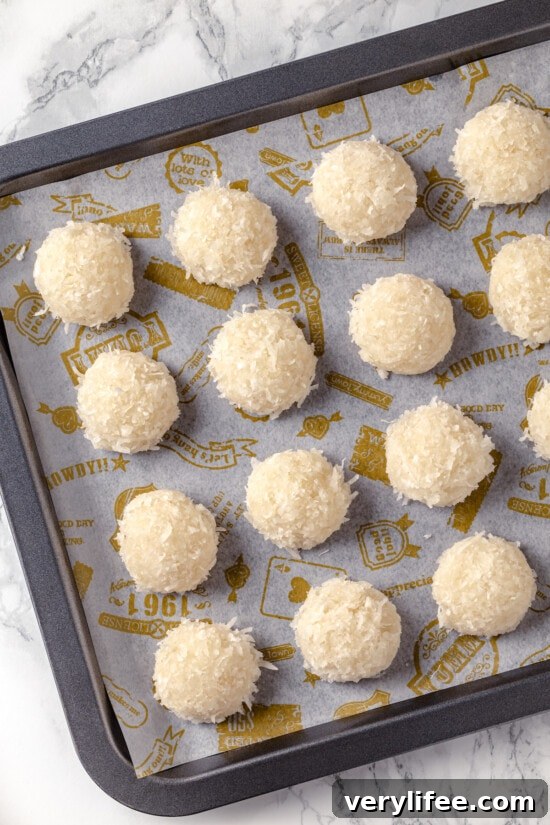 Unbaked macaroons with coconut on a baking sheet