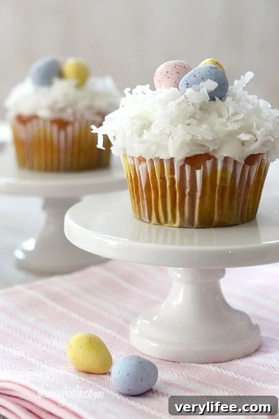 Close-up of coconut cupcake topped with cream cheese frosting and coconut flakes