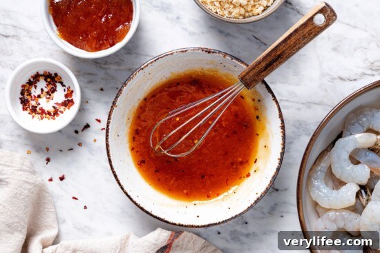 Whisk in bowl of sweet and spicy sauce.