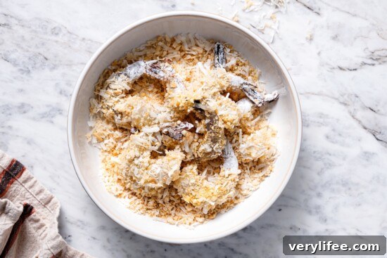 Shrimp being coated in panko and coconut.
