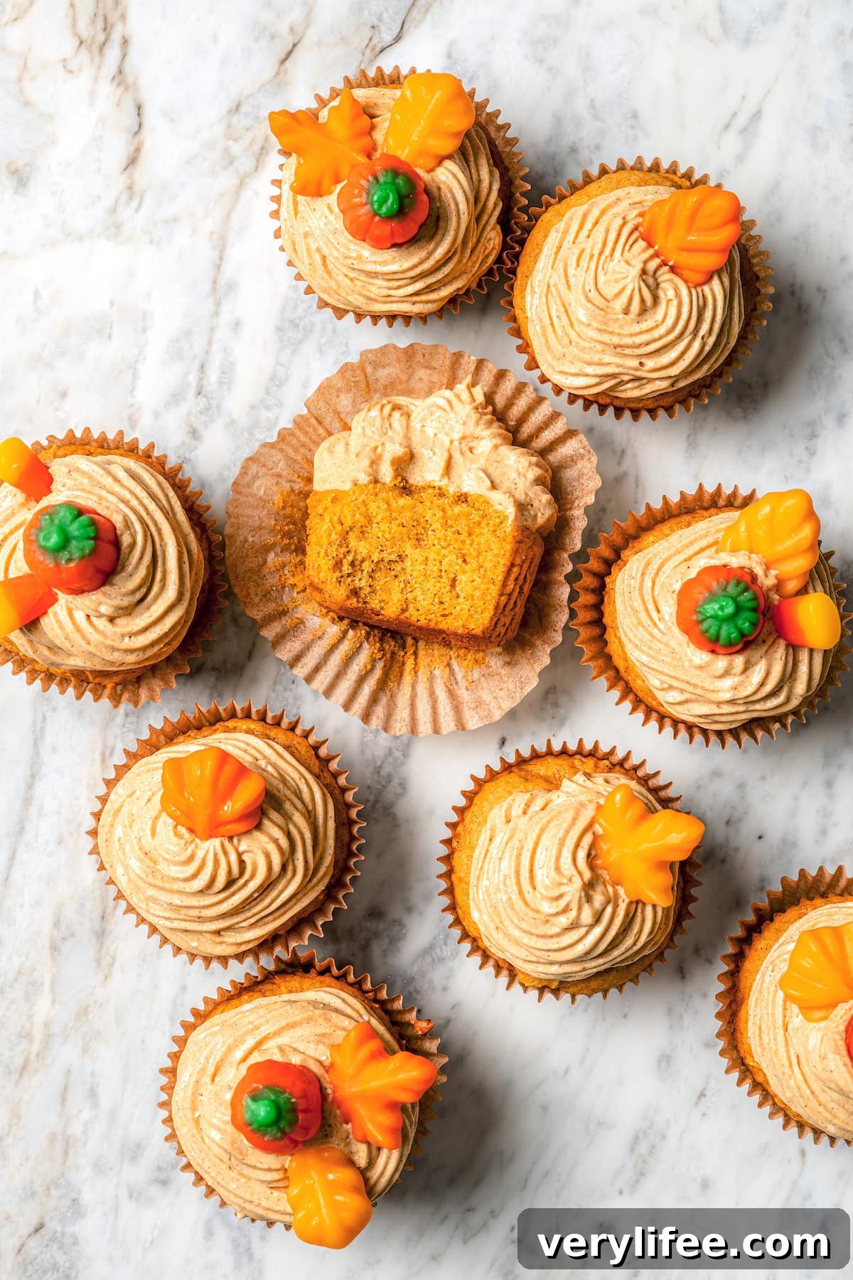 Overhead view of pumpkin cupcakes on marble countertop
