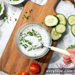 Lighter Buttermilk Ranch Dressing Recipe 2 Bowl of buttermilk ranch dressing on board with spoon.