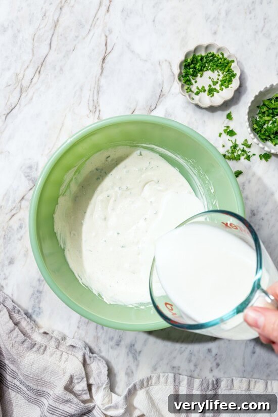 Lighter Buttermilk Ranch Dressing Recipe 5 Pouring buttermilk into bowl for ranch dressing.