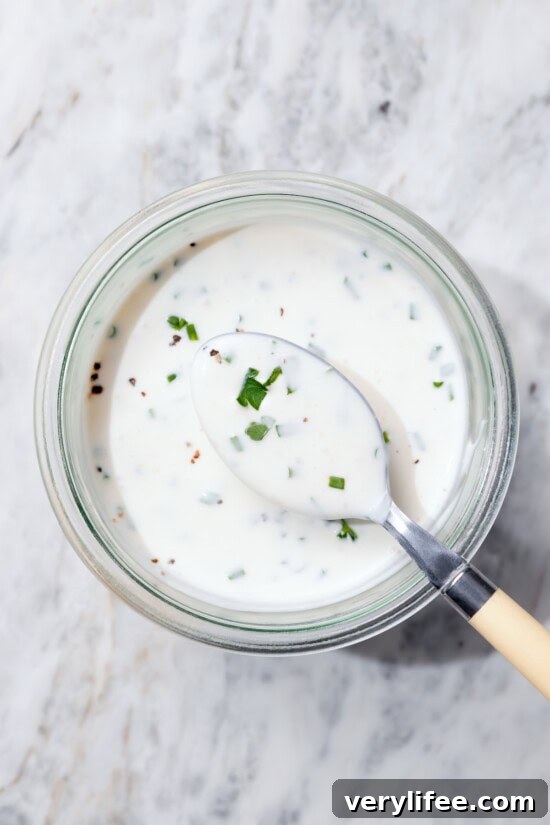 Lighter Buttermilk Ranch Dressing Recipe 6 Spoonful of buttermilk ranch dressing set in bowl.
