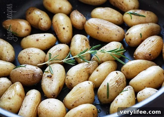 Roasted Fingerling Potatoes with Rosemary 2 Fingerling potatoes with rosemary in a skillet, golden and seasoned.