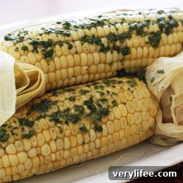 Sweet summer corn roasted in the oven and topped off with a light compound butter using fresh cilantro and a pinch of chipotle pepper and cumin.