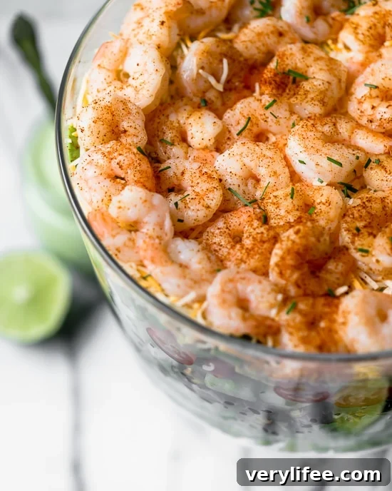 Mexican Shrimp Cobb Salad is a beautifully layered salad with shrimp, avocados, grilled corn, black bean salsa, cucumbers, tomatoes and cheese.