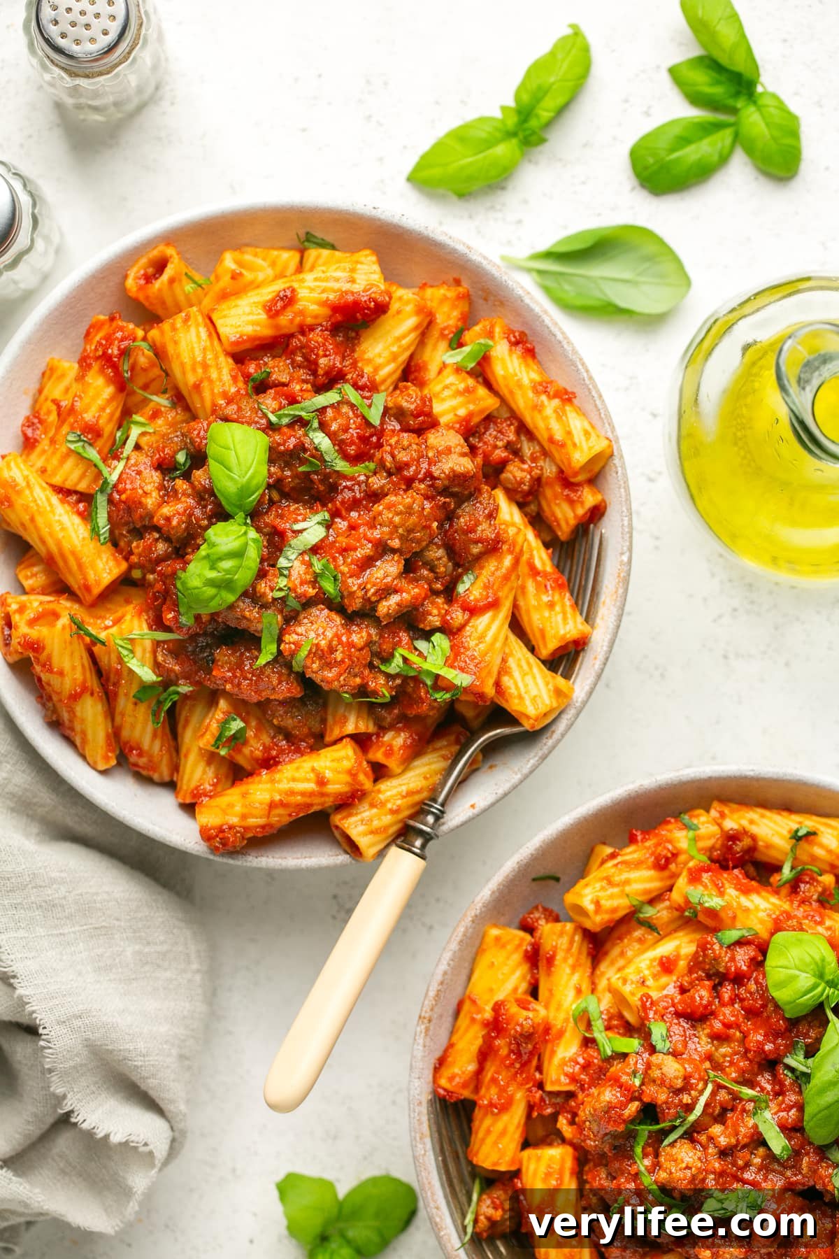 Crock Pot Sausage Pasta Sauce Recipe 8 Overhead view of two bowls with sausage pasta sauce served over rigatoni.