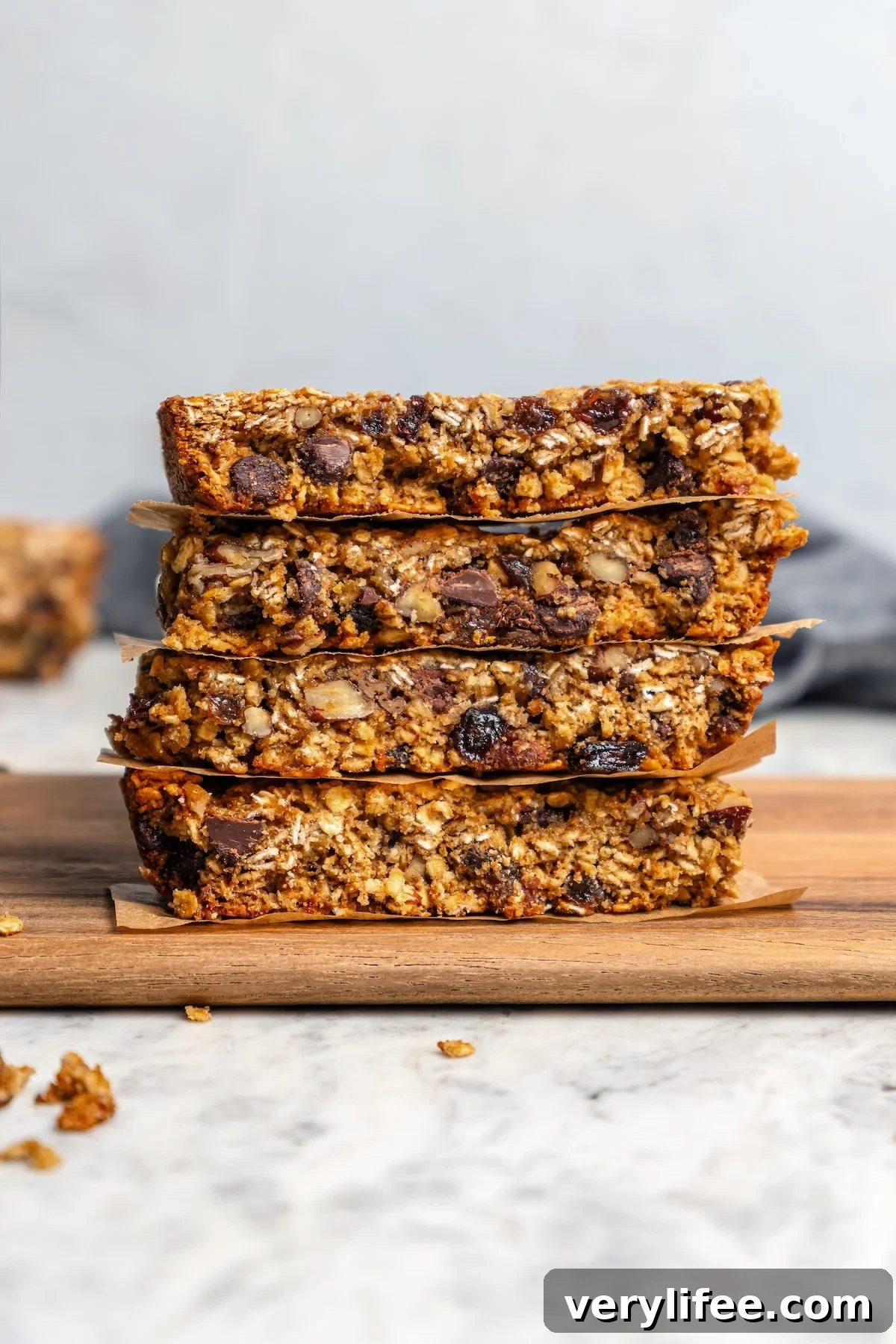 Chewy granola bars with pecans, raisins, and chocolate chips Stack of 4 chewy granola bars with chocolate chips, pecans, and raisins.