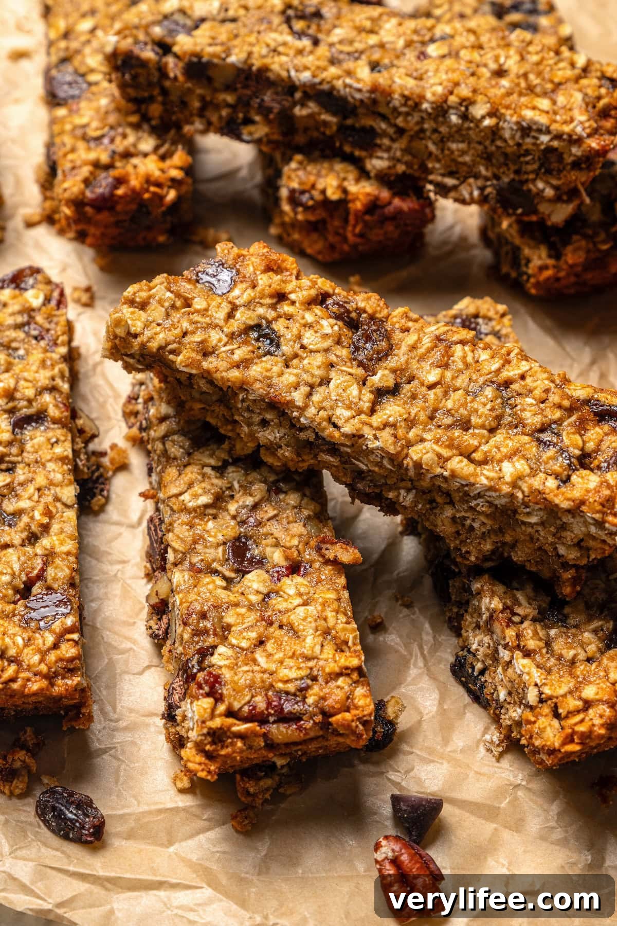 Homemade Chewy Pecan, Raisin and Chocolate Chip Granola Bars 9 Chewy granola bars piled on parchment paper.